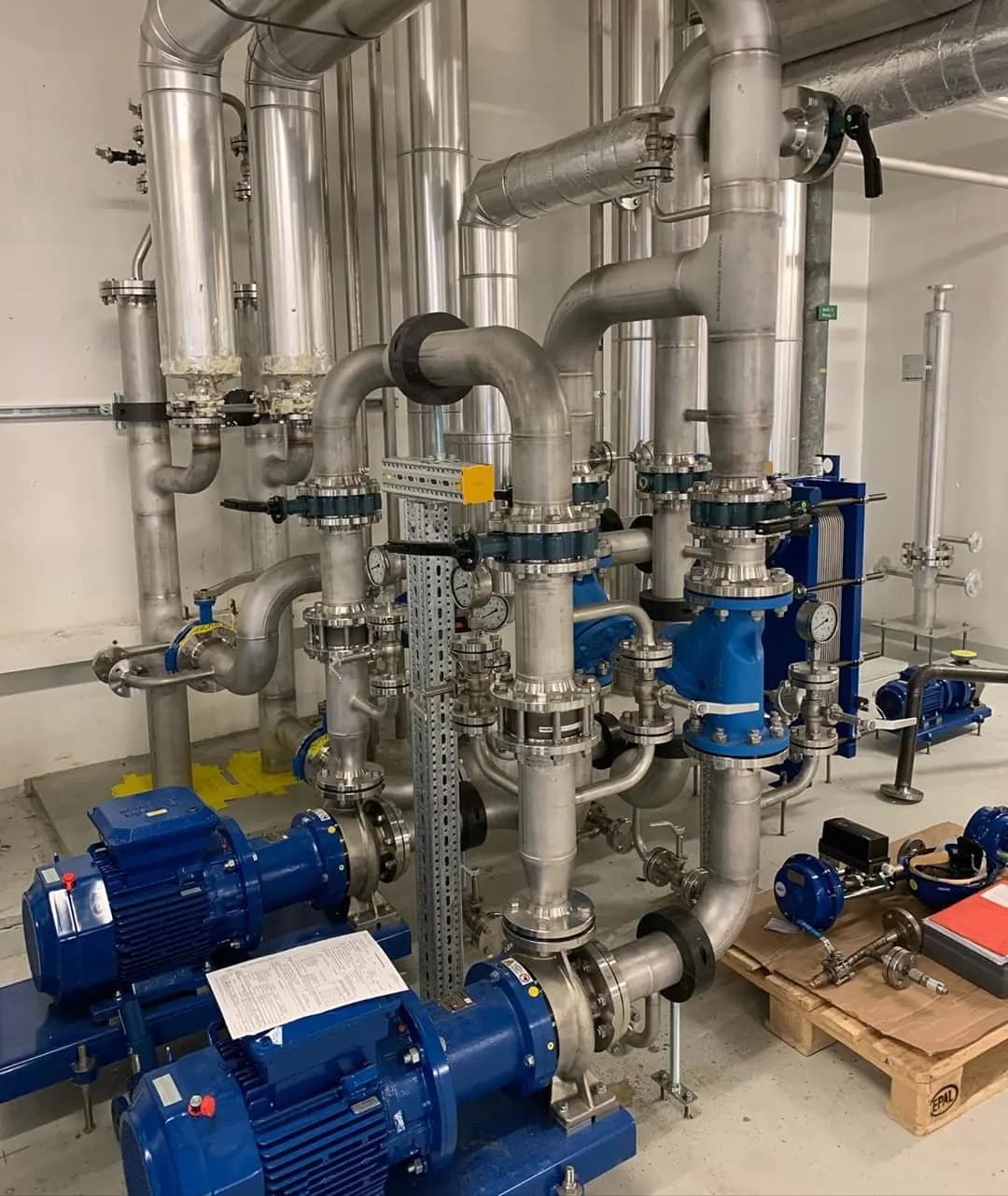 Edelstahl-Rohrleitungen mit Pumpen in einer Produktionsanlage
